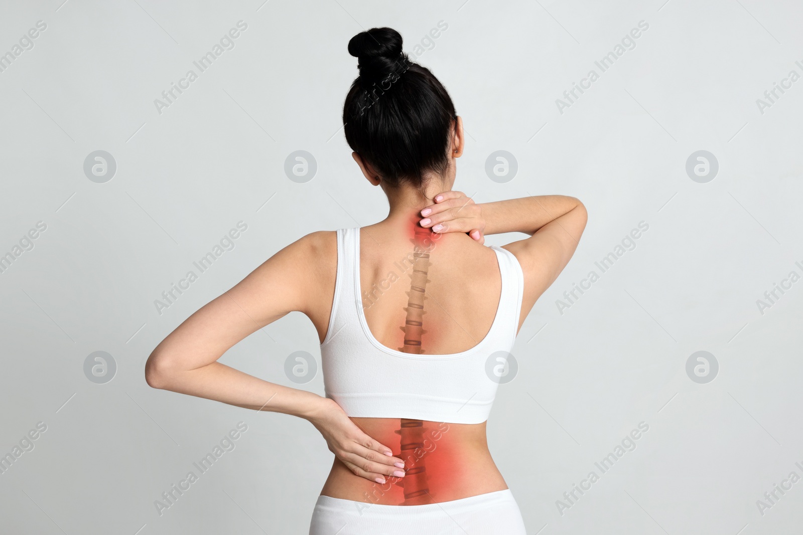 Image of Woman suffering from pain in back on light background