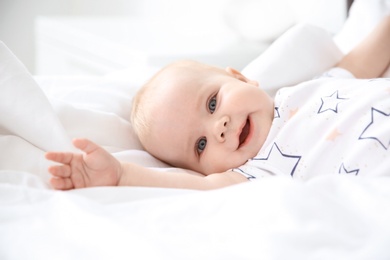 Photo of Cute smiling little baby lying on bed