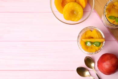 Photo of Tasty peach dessert with yogurt served on pink wooden table, flat lay. Space for text