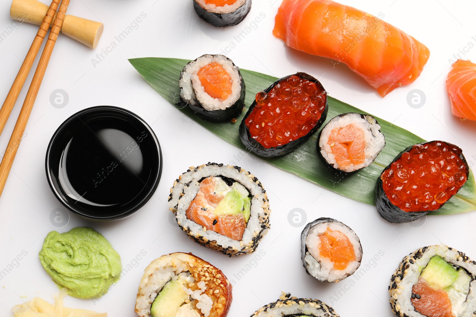 Photo of Set of delicious sushi rolls on white background, flat lay