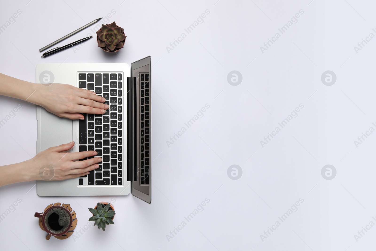 Photo of Woman using laptop at white table, top view. Space for text