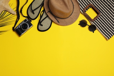 Photo of Flat lay composition with stylish beach accessories on yellow background, space for text