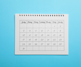 Photo of Paper calendar on light blue background, top view