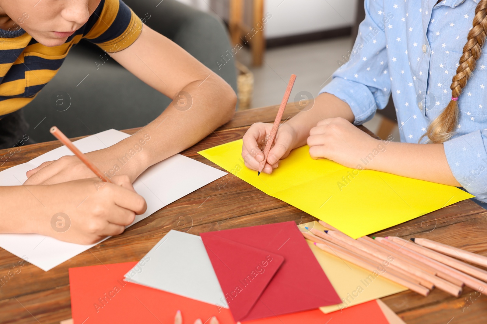 Photo of Children making beautiful greeting cards at table indoors, closeup