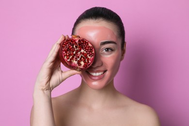 Photo of Woman with pomegranate face mask and fresh fruit on pink background