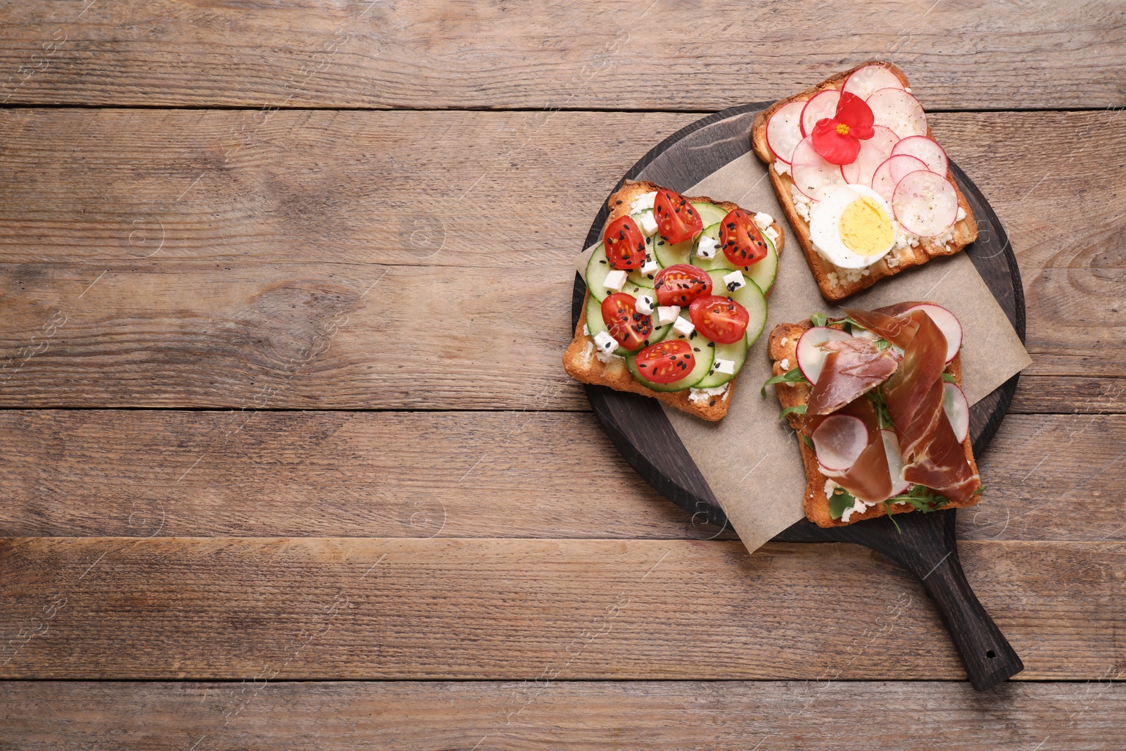 Photo of Different delicious sandwiches on wooden table, top view. Space for text