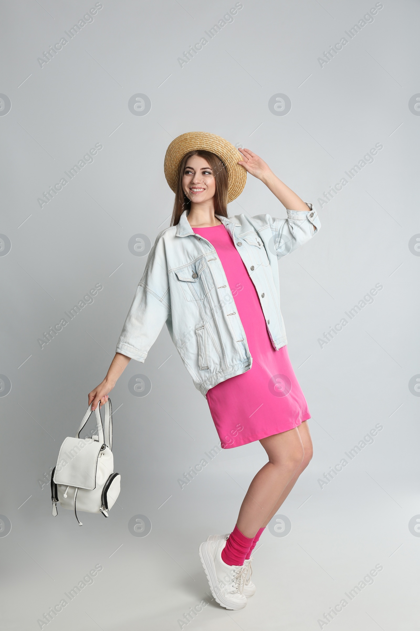 Photo of Beautiful young woman with stylish bag on grey background