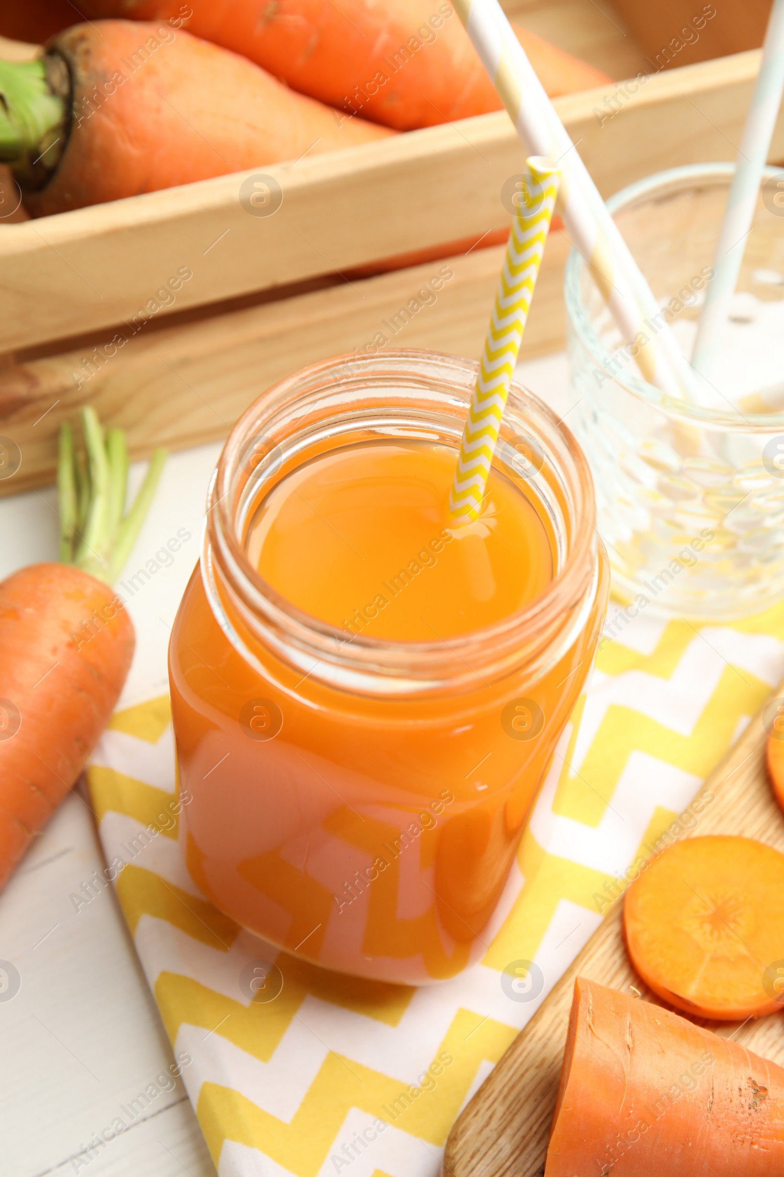Photo of Freshly made carrot juice in mason jar on white wooden table