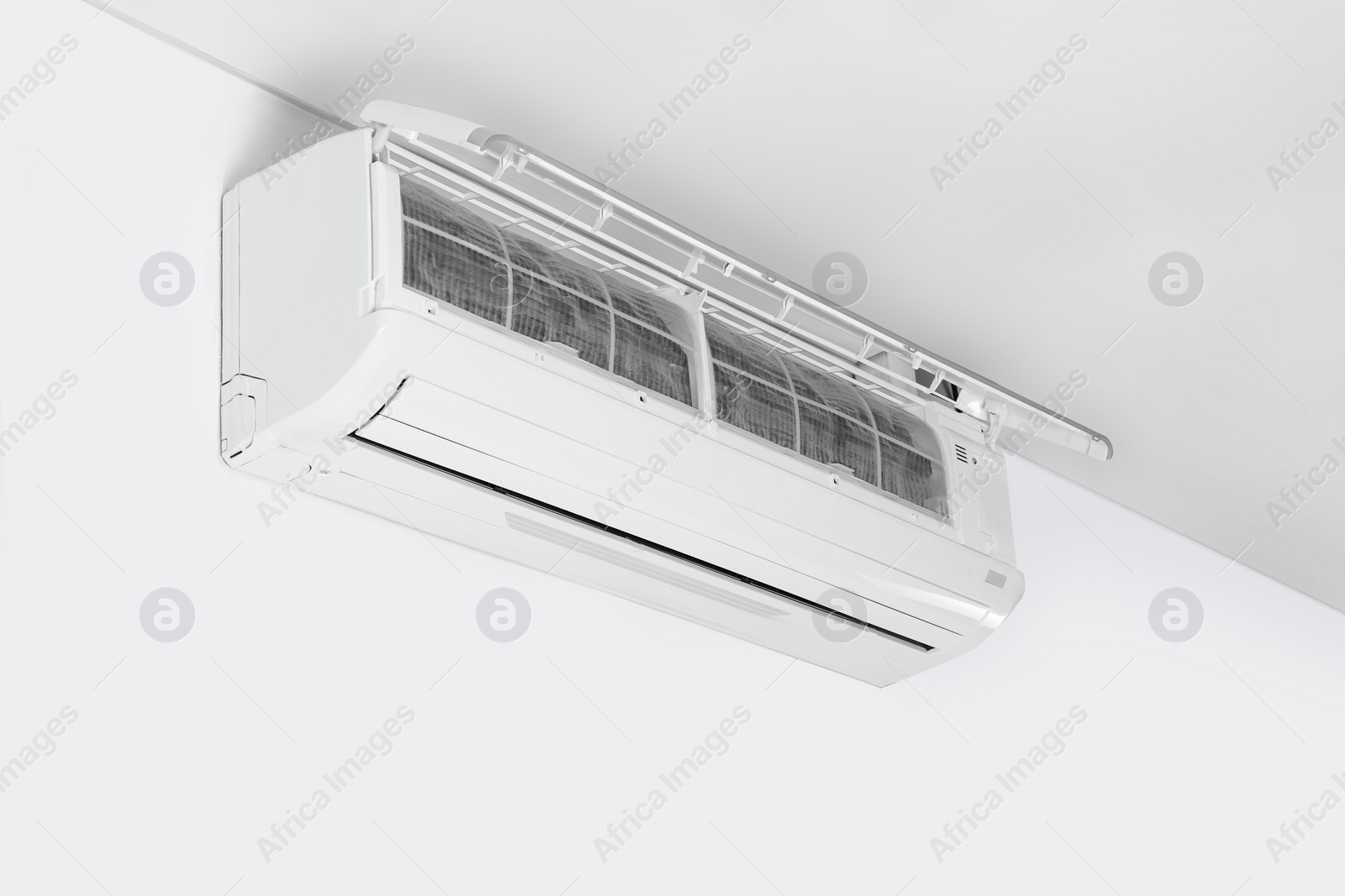 Photo of Modern air conditioner on white wall indoors