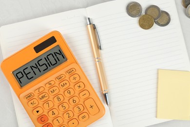 Calculator with word Pension, coins and stationery on light grey table, top view