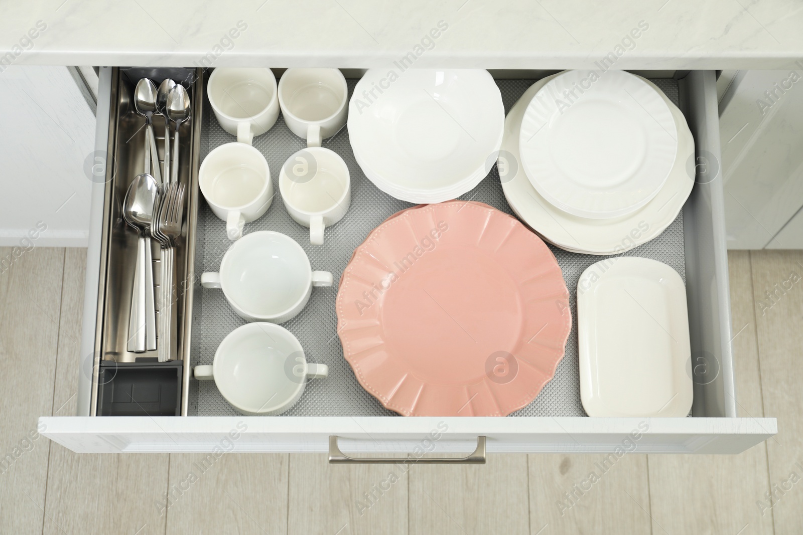 Photo of Clean plates, bowls, cups and cutlery in drawer indoors, top view