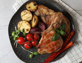 Photo of Delicious grilled meat and vegetables on light grey table, top view