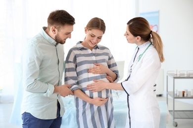 Photo of Gynecology consultation. Future parents with doctor in hospital