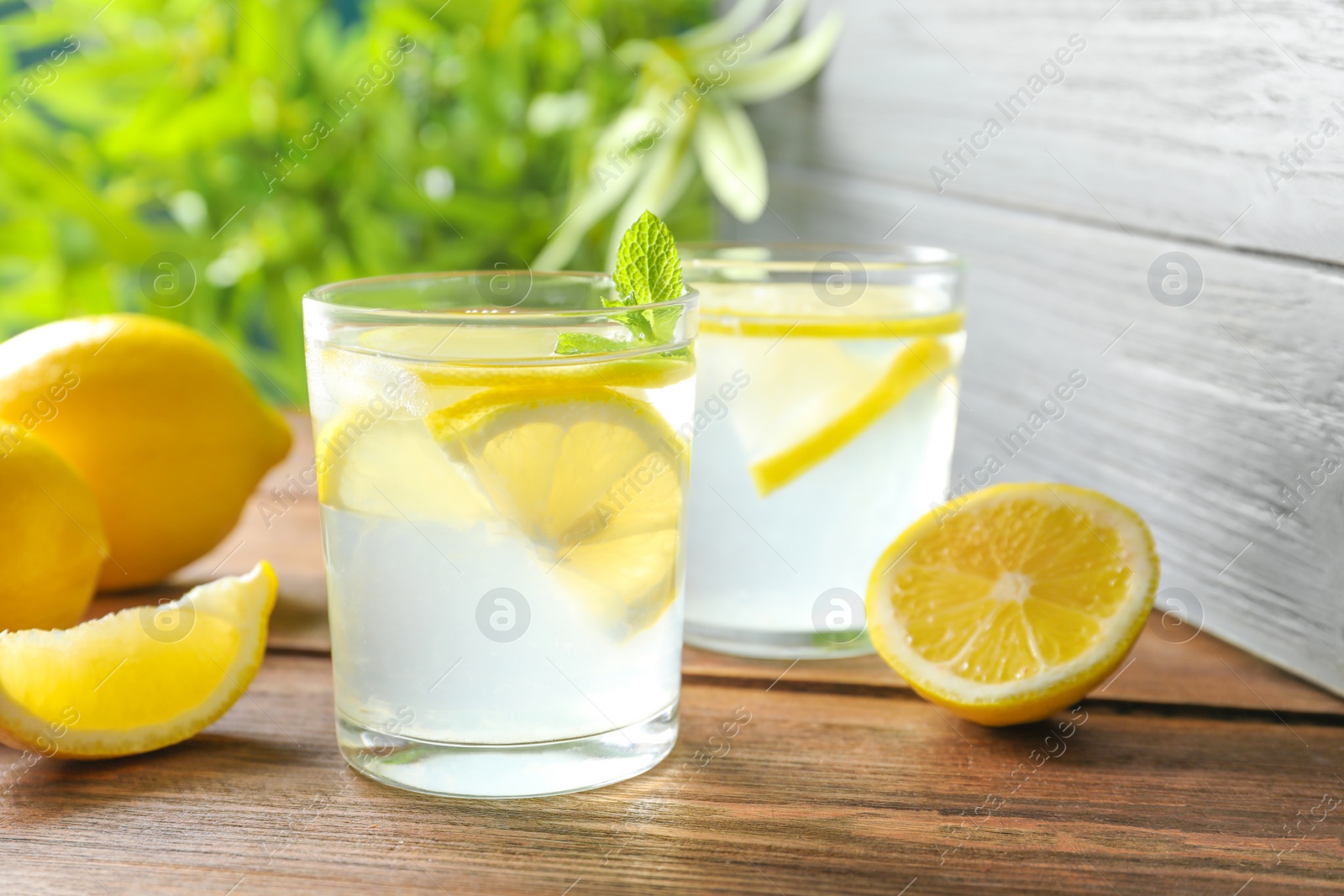 Photo of Natural lemonade with mint in glasses on wooden table
