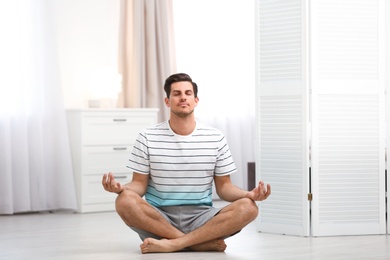 Man meditating on floor at home. Zen concept