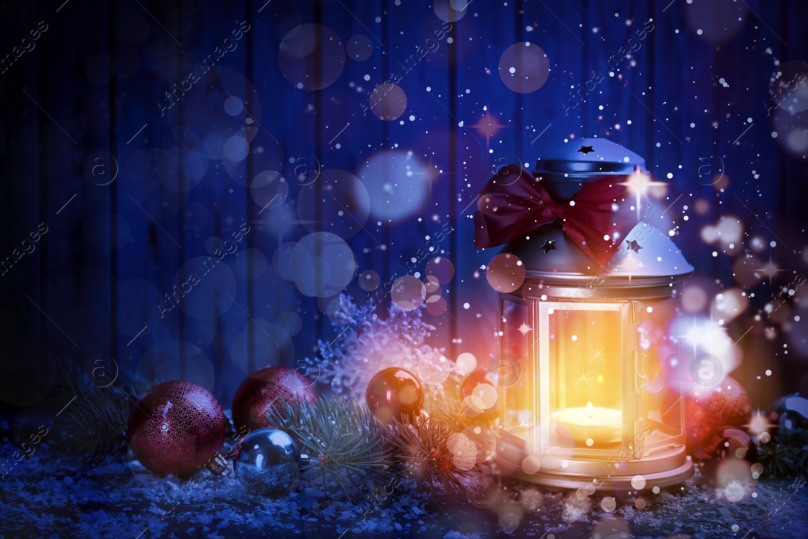 Image of Christmas lantern with burning candle and festive decor on table. Magical atmosphere