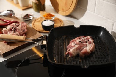 Frying pan with fresh raw meat on stove