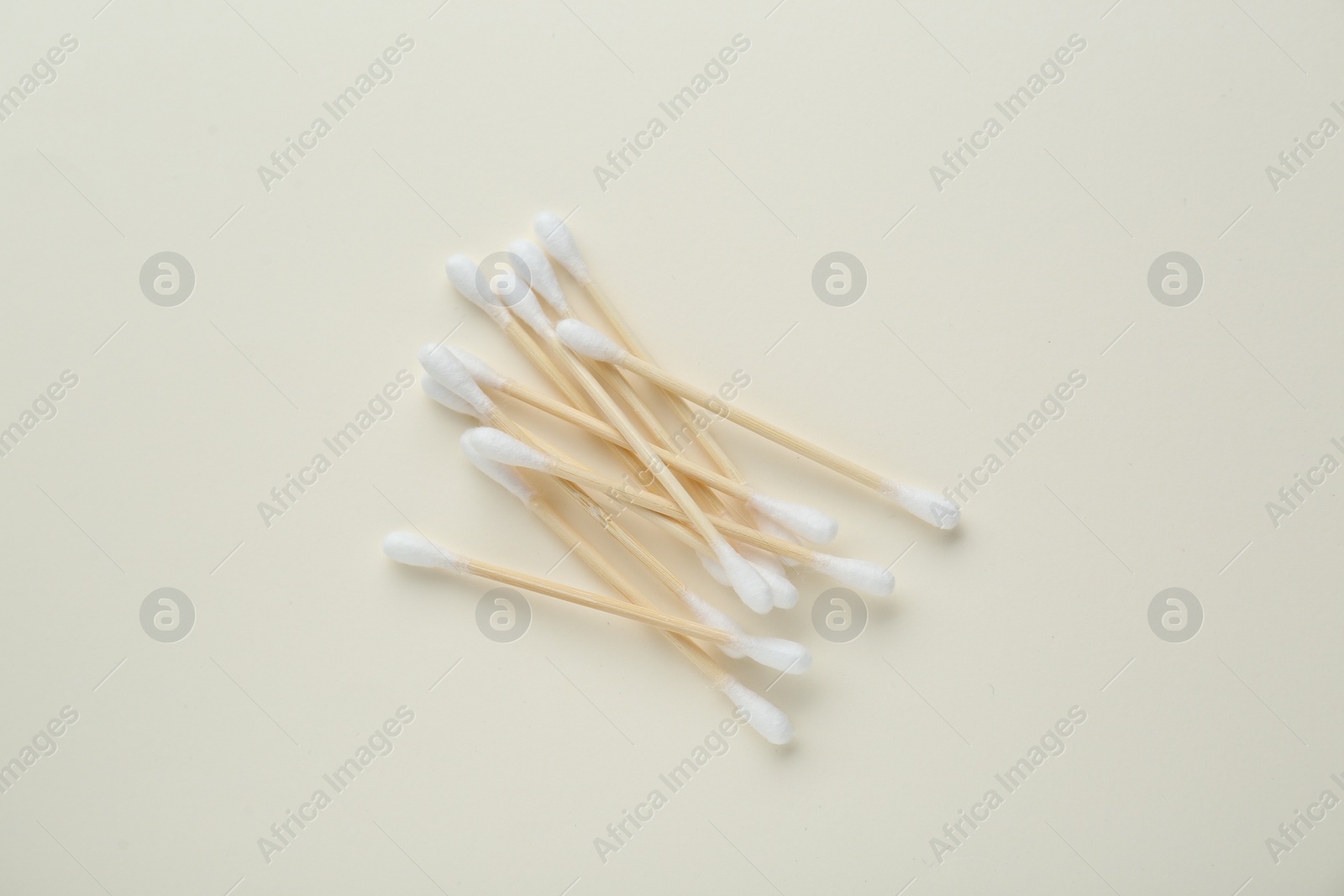 Photo of Heap of wooden cotton buds on beige background, flat lay