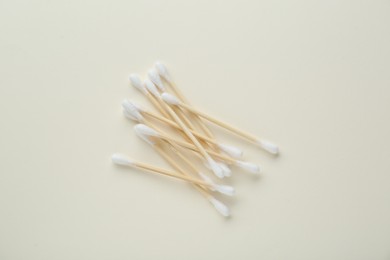 Photo of Heap of wooden cotton buds on beige background, flat lay