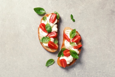 Photo of Toasted bread with tasty cream cheese and tomatoes on gray background, flat lay