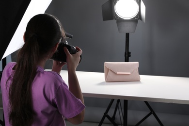 Professional photographer shooting stylish bag in studio