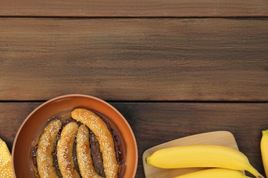 Photo of Delicious fresh and fried bananas on wooden table, flat lay. Space for text