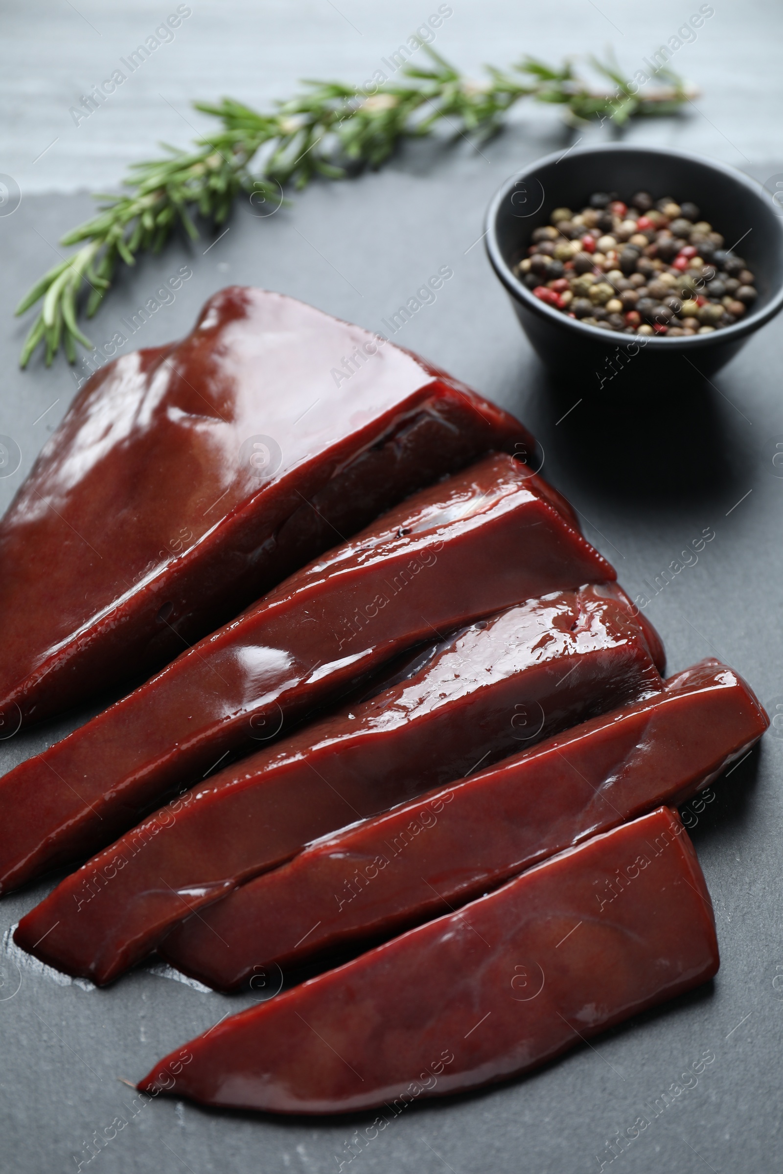 Photo of Cut raw beef liver on black table, closeup