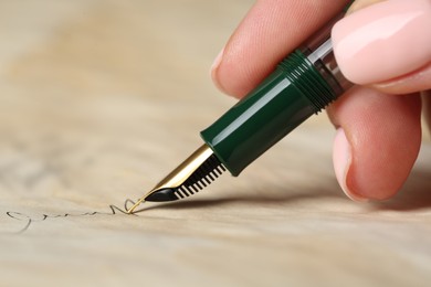 Photo of Woman writing letter with fountain pen, closeup