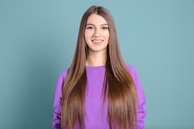 Portrait of young woman with long beautiful hair on light background