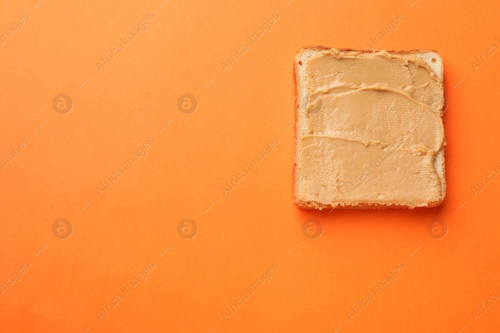 Photo of Tasty peanut butter sandwich on orange background, top view. Space for text