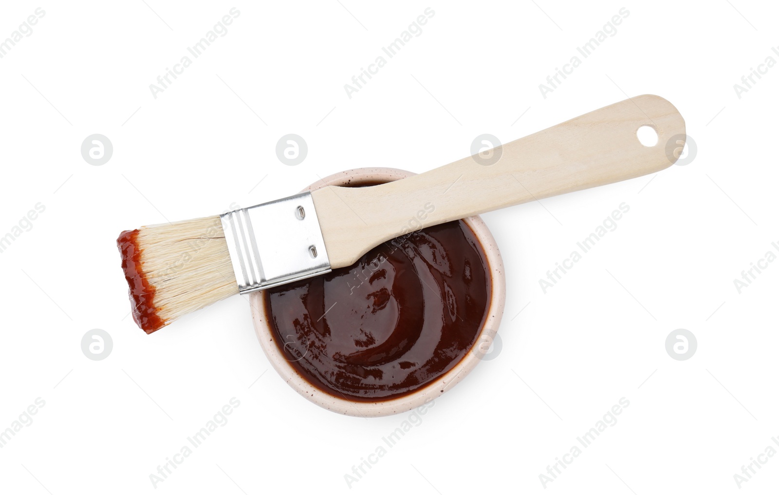 Photo of Marinade in bowl and basting brush isolated on white, top view