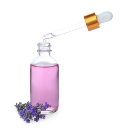 Photo of Dripping essential oil from pipette into bottle and lavender flowers isolated on white