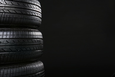 Stack of car tires on black background, closeup