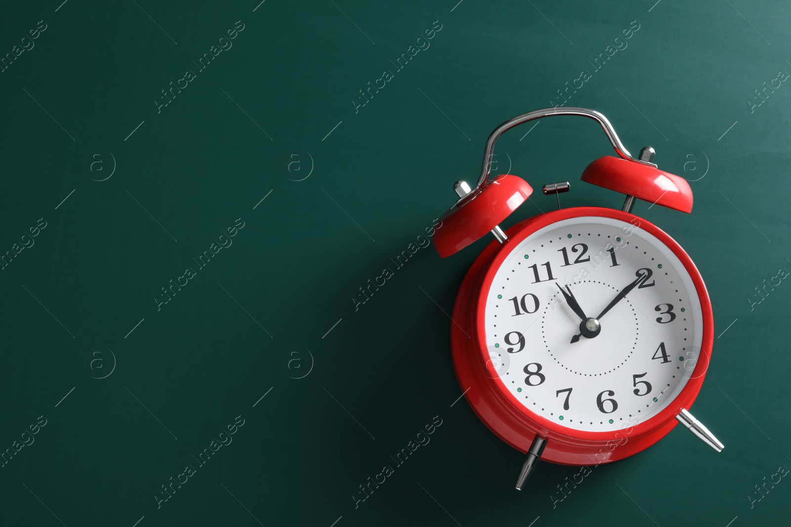 Photo of Alarm clock and space for text on green background, above view. School time