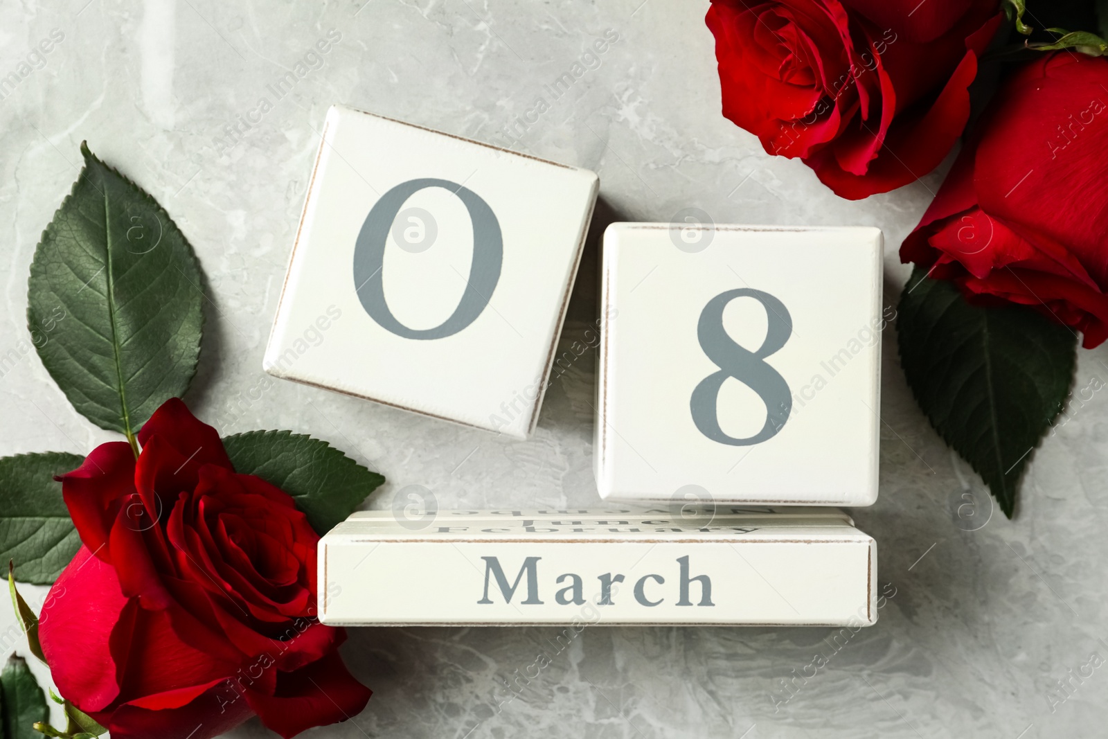 Photo of Block calendar with date 8th of March and roses on light grey marble background, flat lay. International Women's Day