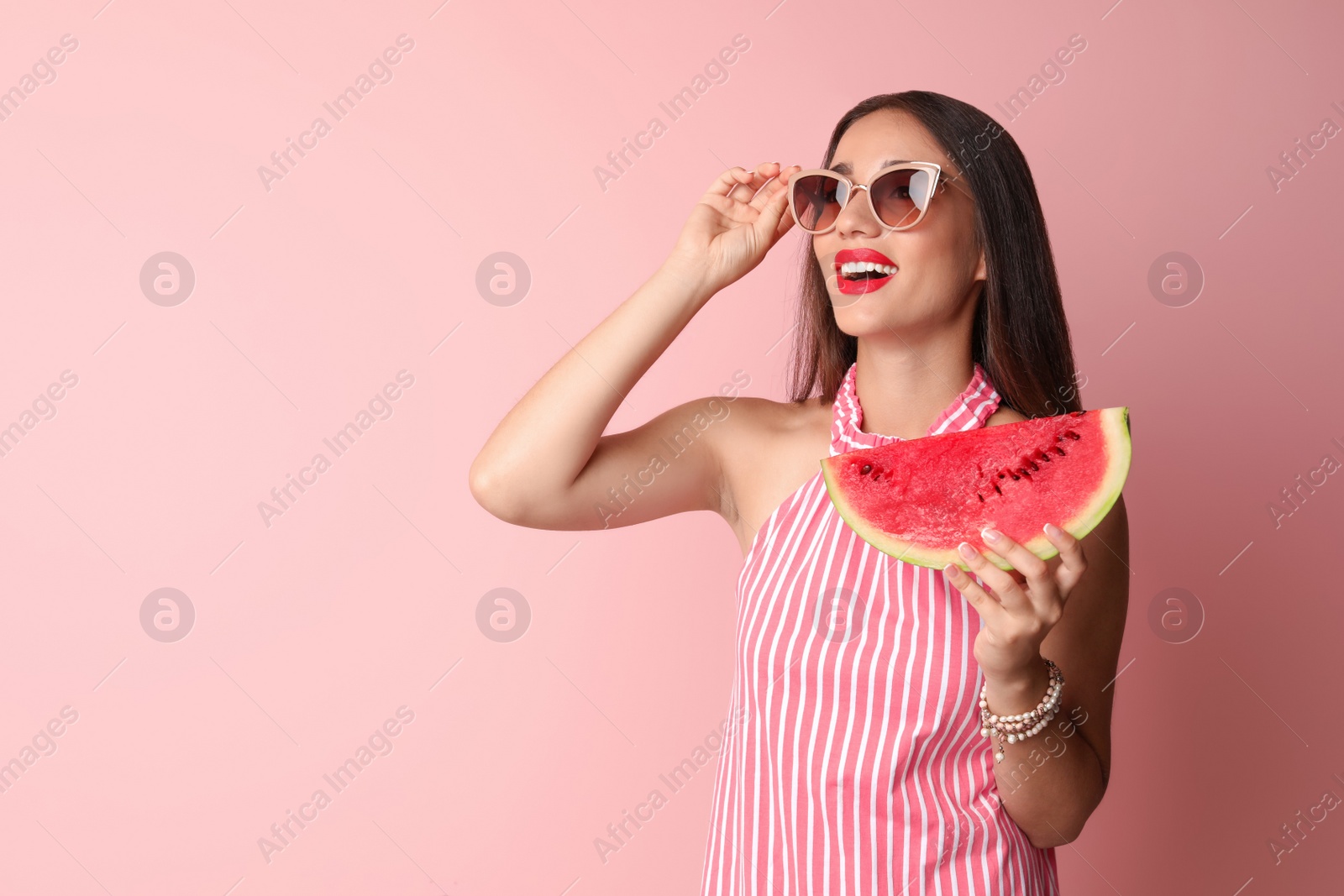 Photo of Beautiful young woman posing with watermelon on color background