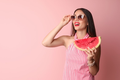 Beautiful young woman posing with watermelon on color background