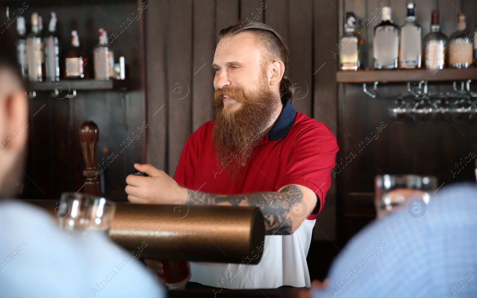 Photo of Bartender working at beer tap in pub