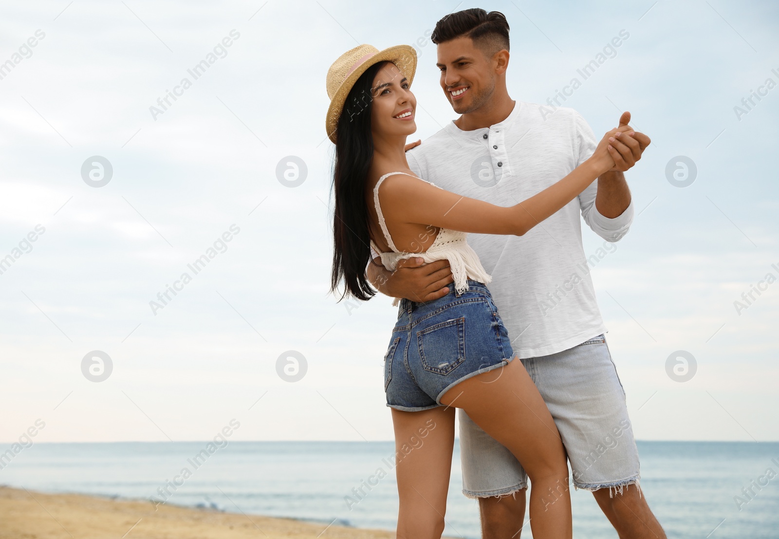 Photo of Lovely couple dancing on beach near sea