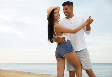 Lovely couple dancing on beach near sea