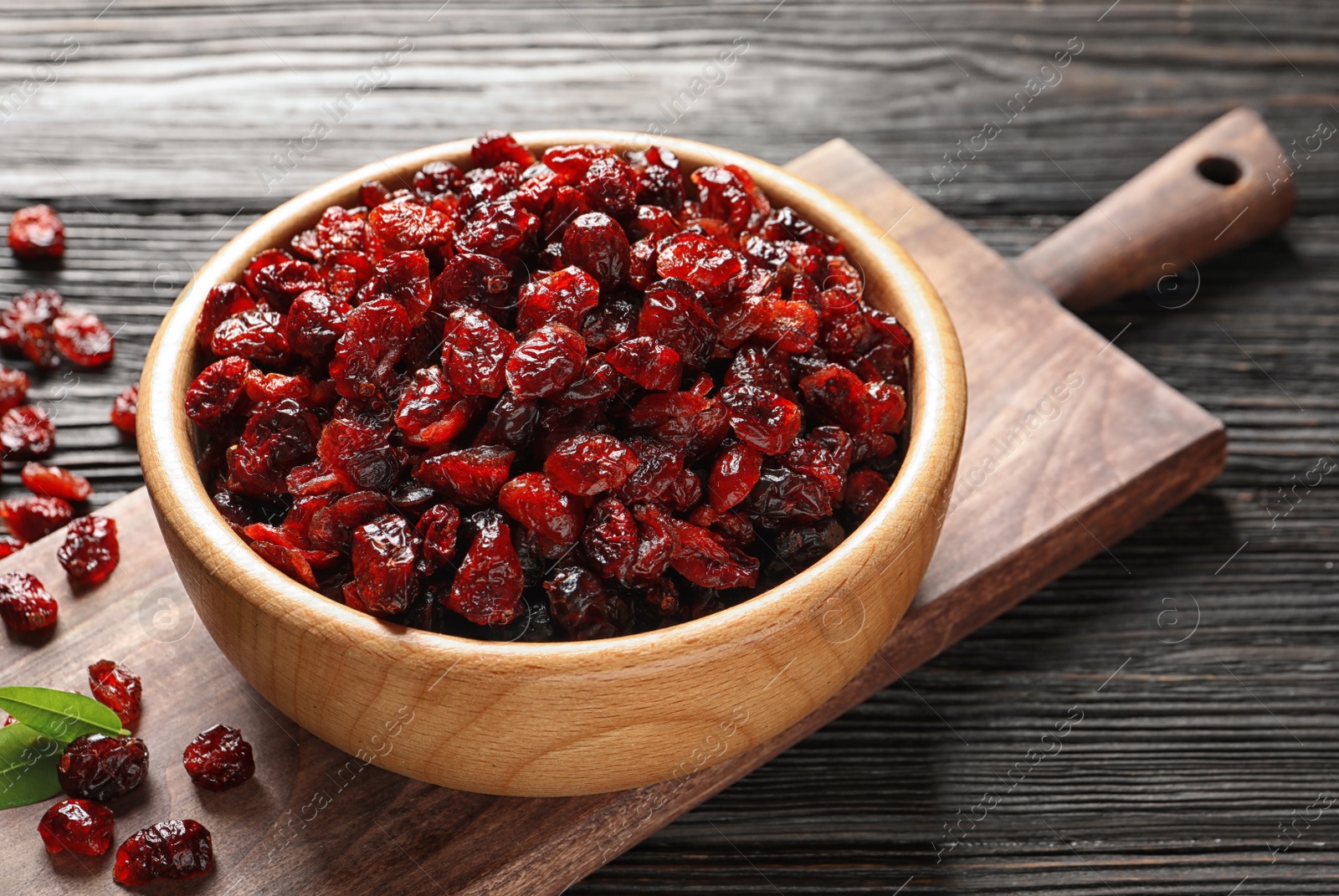 Photo of Bowl with cranberries on wooden table. Dried fruit as healthy snack