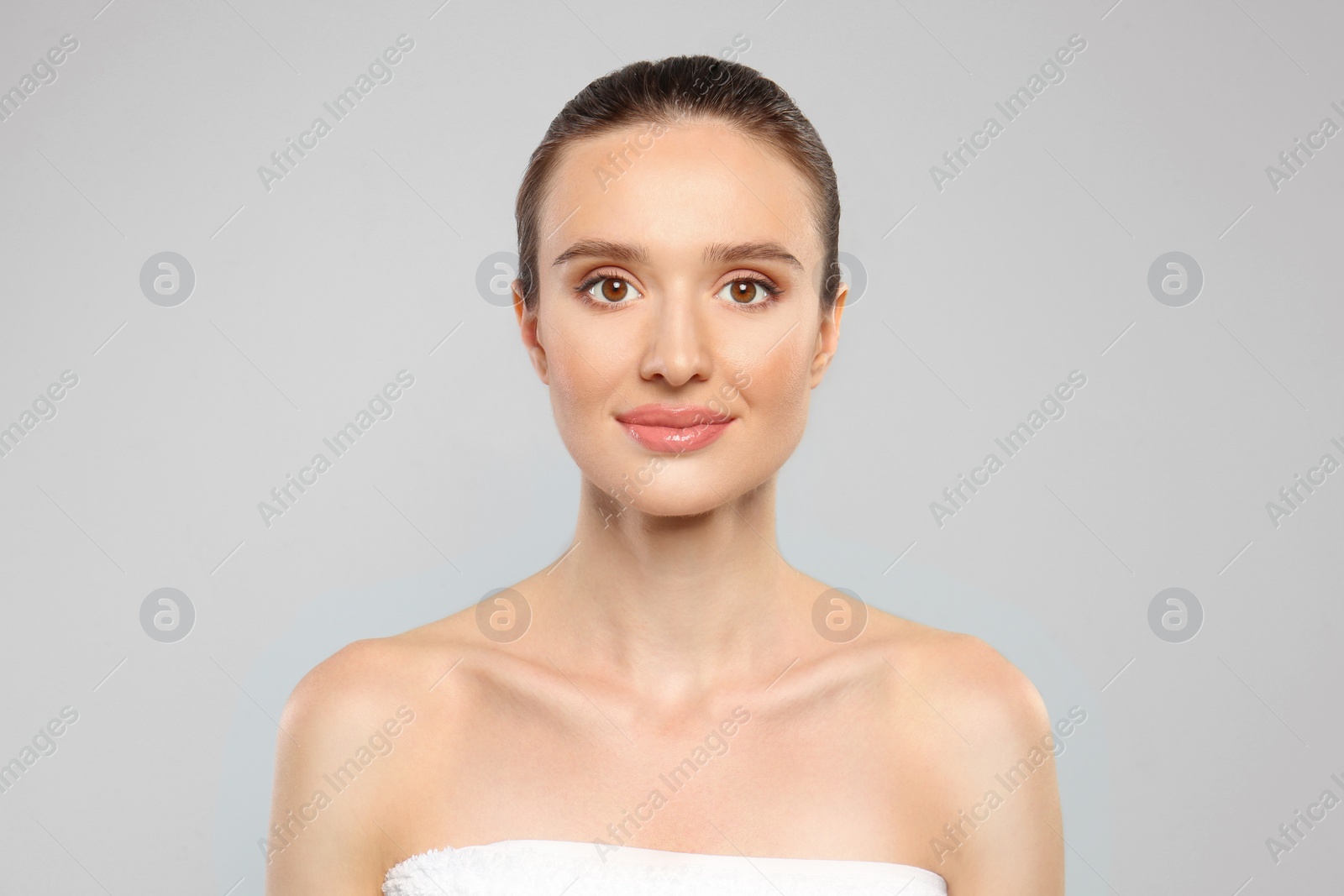 Photo of Portrait of beautiful young woman with perfect skin on grey background. Spa treatment