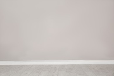 Photo of Empty room with beautiful beige wall and wooden floor
