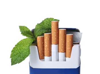 Photo of Pack of menthol cigarettes and fresh mint leaves on white background