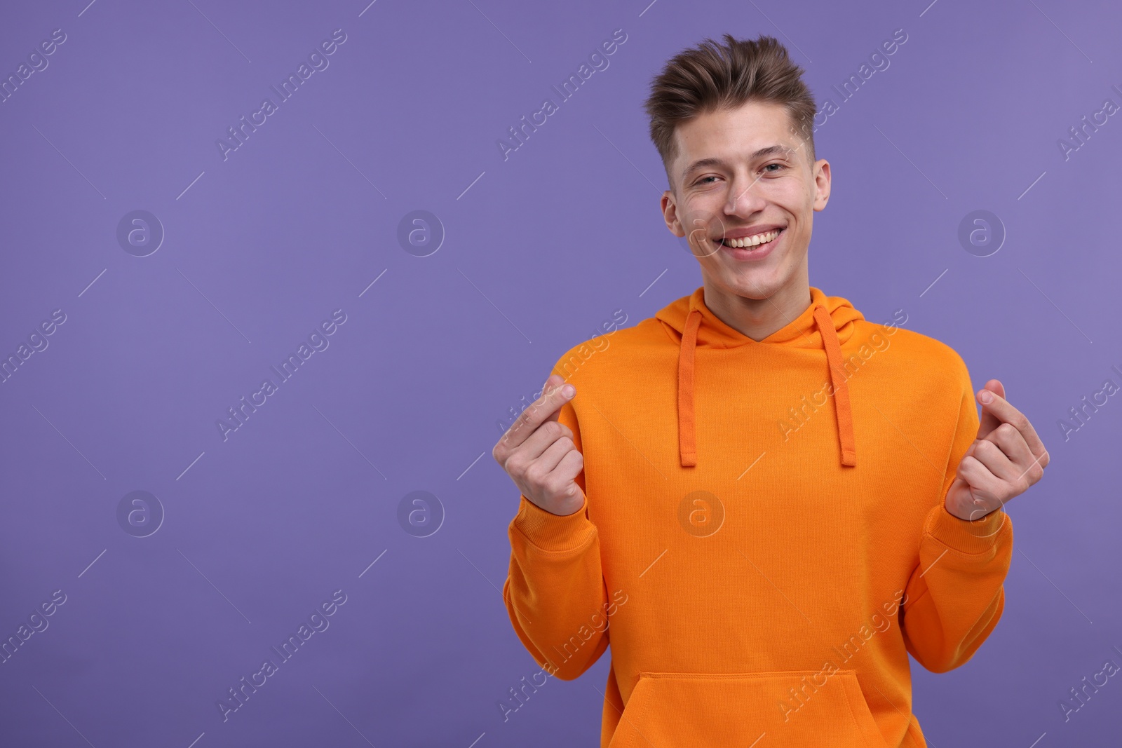 Photo of Happy man showing money gesture on purple background. Space for text