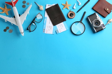 Photo of Flat lay composition with toy airplane and travel items on light blue background. Space for text