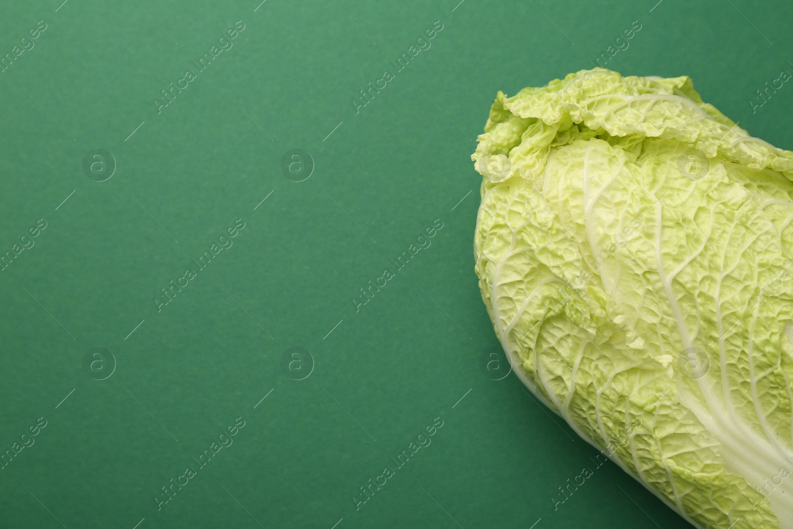 Photo of Fresh ripe Chinese cabbage on green background, top view. Space for text