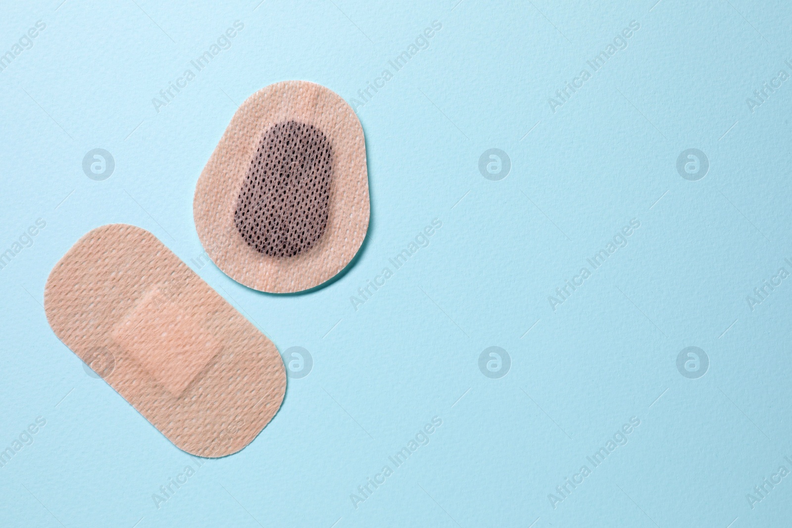 Photo of Contraceptive patches on light blue background, flat lay. Space for text