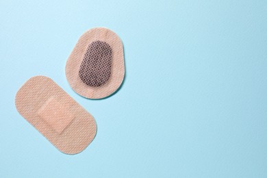 Photo of Contraceptive patches on light blue background, flat lay. Space for text