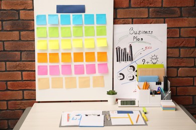 Business process planning and optimization. Workplace with colorful paper notes and other stationery on table
